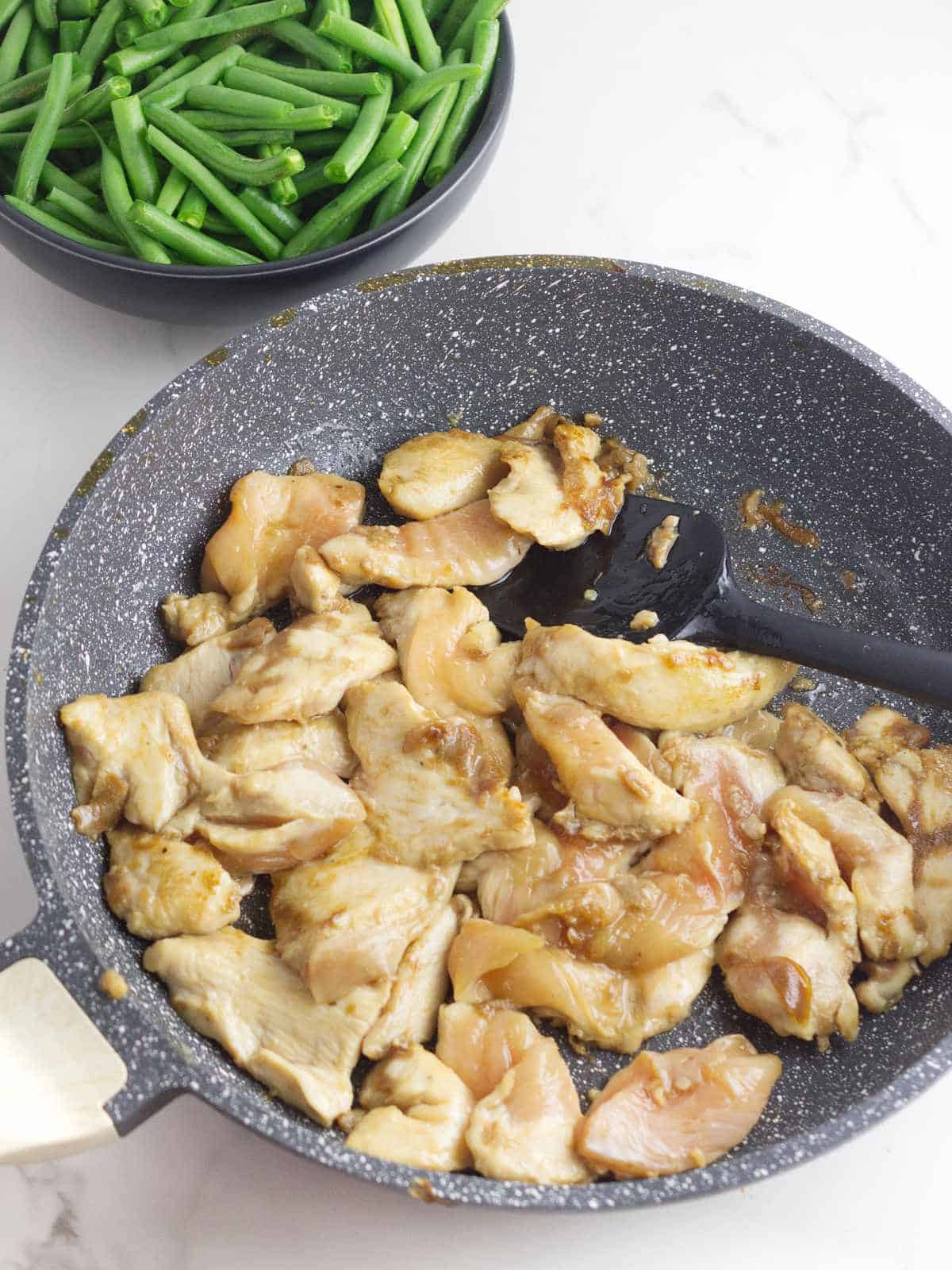 sauteed chicken breast slices in a skillet.