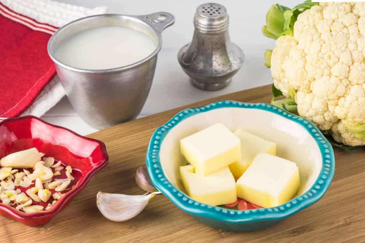 Close up of ingredients - cauliflower cabbage, garlic and butter cream formashed cauliflower.